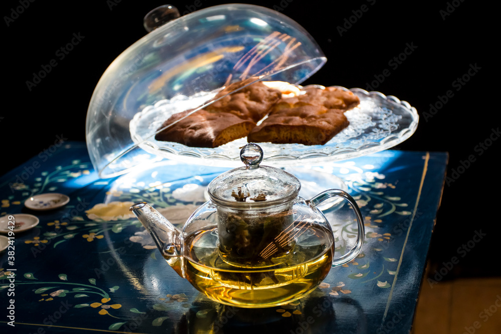 Cup of fresh flower and herb arabic tea and some Tasty and healthy almond cookies, rich in vitamins and less sugar. copy space.Top view on a blue flowers background..