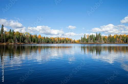 Blue lake with treeline in autumn color on a sunny afternoon in northern Minnesota photo