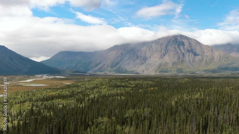 Beautiful View of Rocky Mountains, Land and Forest on a Cloudy Summer Day in Canadian Nature. Aerial Drone Shot. Yukon, Canada. 4K Beautiful View of Rocky Mountains, Land and Forest on a Cloudy Summer Day in Canadian Nature. Aerial Drone Shot. Yukon, Canada. 4K