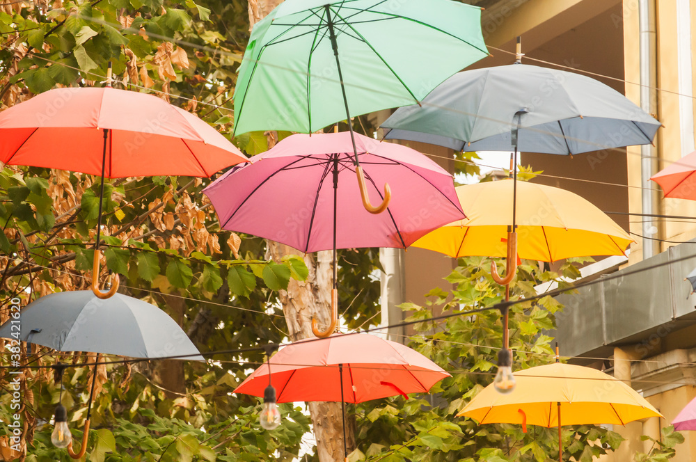 Umbrellas in different colors hanging over city street