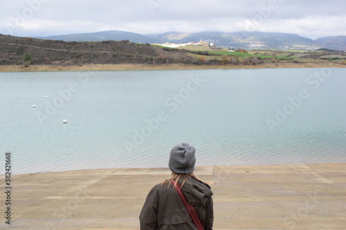 Blond girl in front of a huge lake in autum