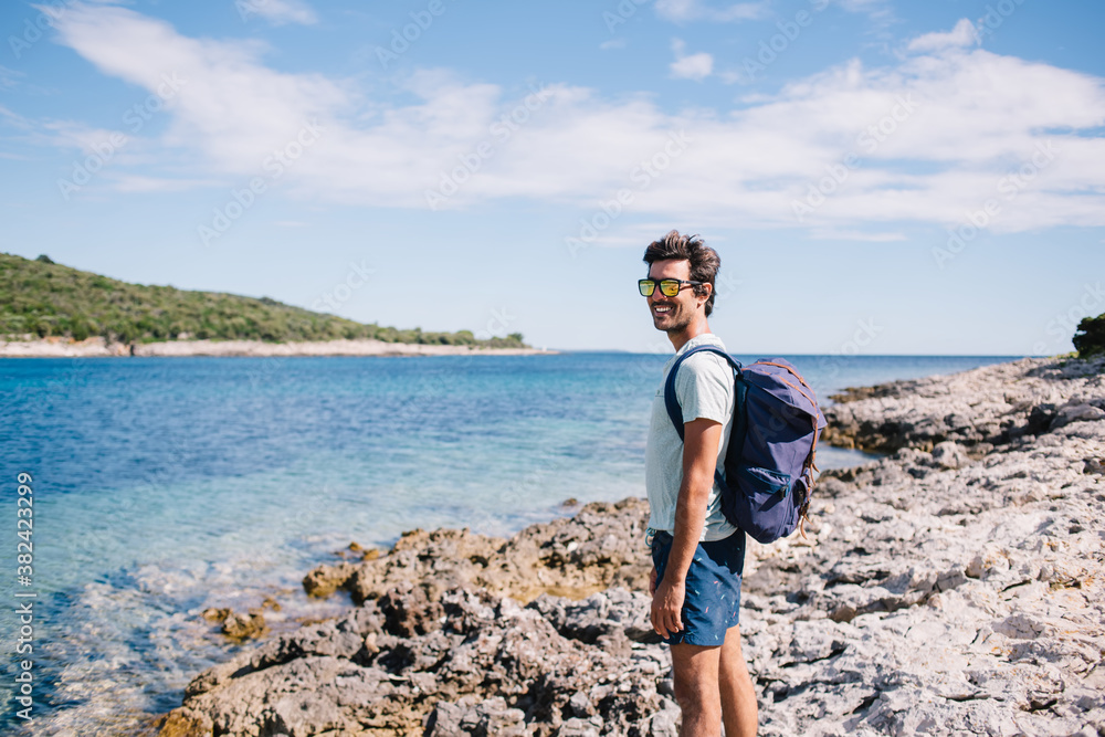 Man with backpack on seashore
