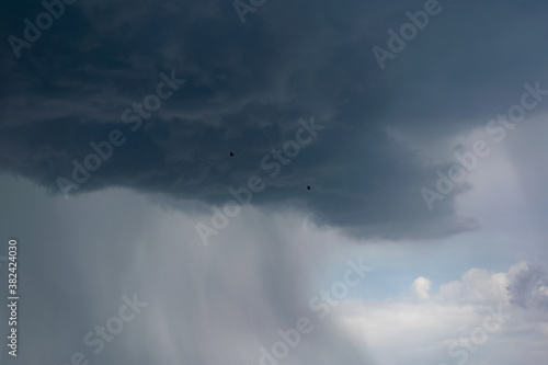 Dark storm clouds and gray gloomy clouds, a terrible natural phenomenon, rain from afar, view from the side © Анна Иванова