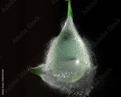 Splashes waterballoon bursting against black background and in a galaxy of water drops closeups photo