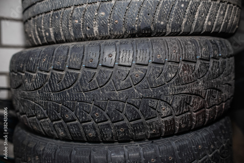 Used car tires against a brick wall. Worn tread of winter tires 