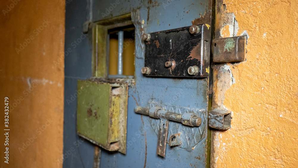 Prison's Windows of Metal Door Protect Prisoner From Inside to Escape. Food Channel Through Prison Cell's Bars. Jail, Detail of Confinement and Crime, Justice. Prison Interior. Limiting Freedom.
