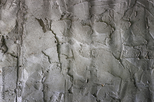 Grunge concrete cement wall with bumps and cracks in industrial building, great for your design and background texture. Copy space.