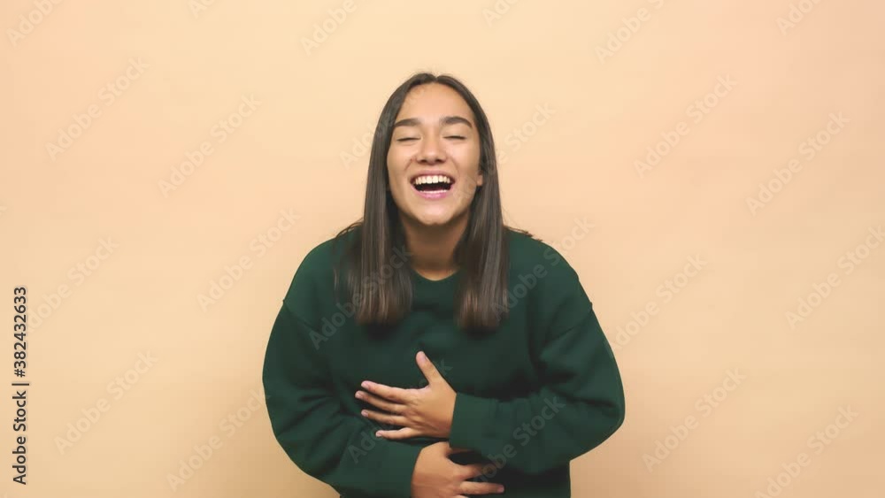 Young mixed race indian woman laughs happily and has fun keeping hands on stomach Young mixed race indian woman laughs happily and has fun keeping hands on stomach