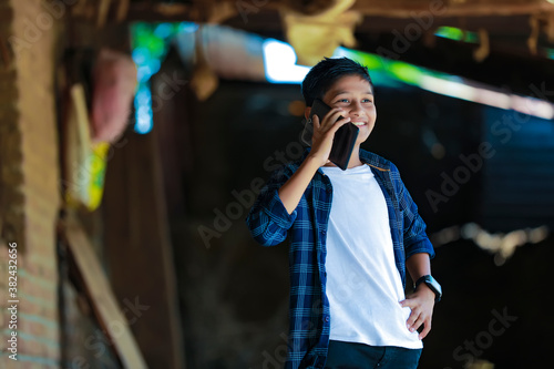 people, children, technology and communication concept - cute indian child talking on smartphone