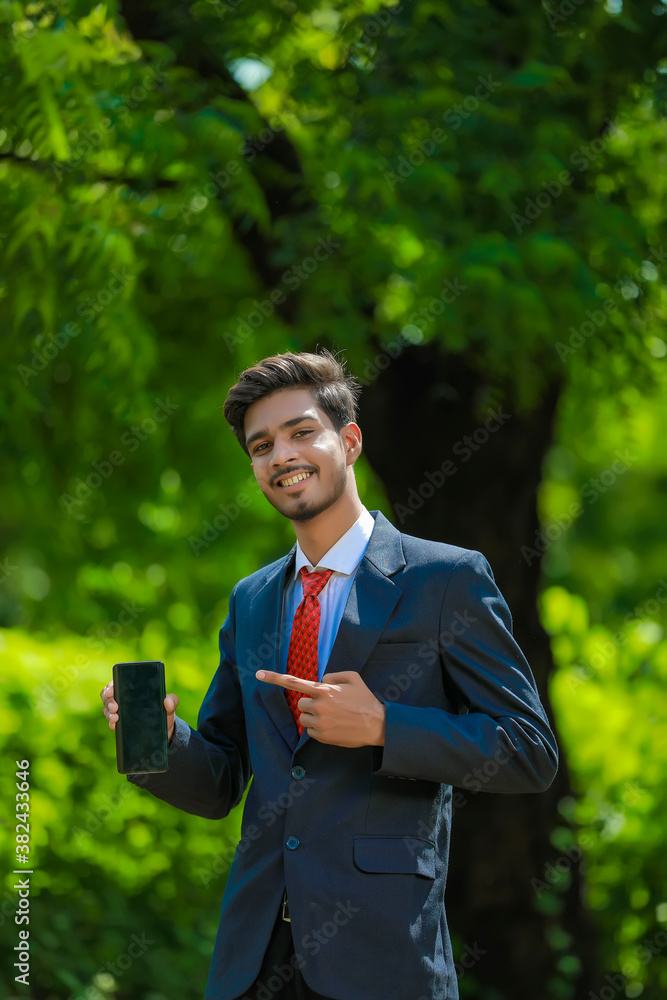 Happy businessman pointing finger on blank smartphone screen Happy businessman pointing finger on blank smartphone screen