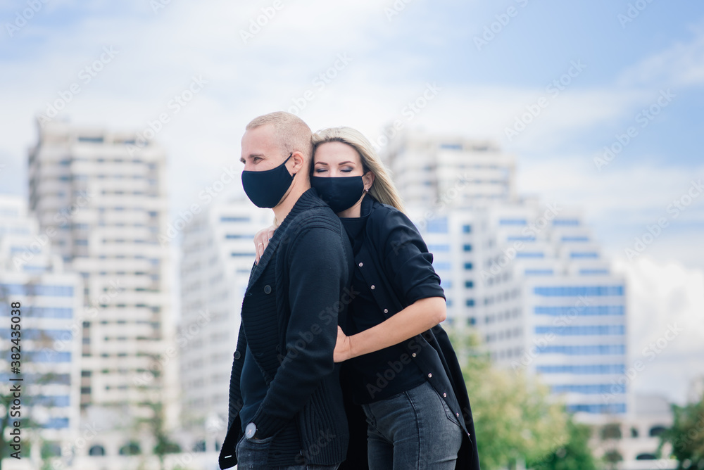 Couple wearing fashionable protective masks, walking in empty street of city during quarantine. Couple wearing fashionable protective masks, walking in empty street of city during quarantine.