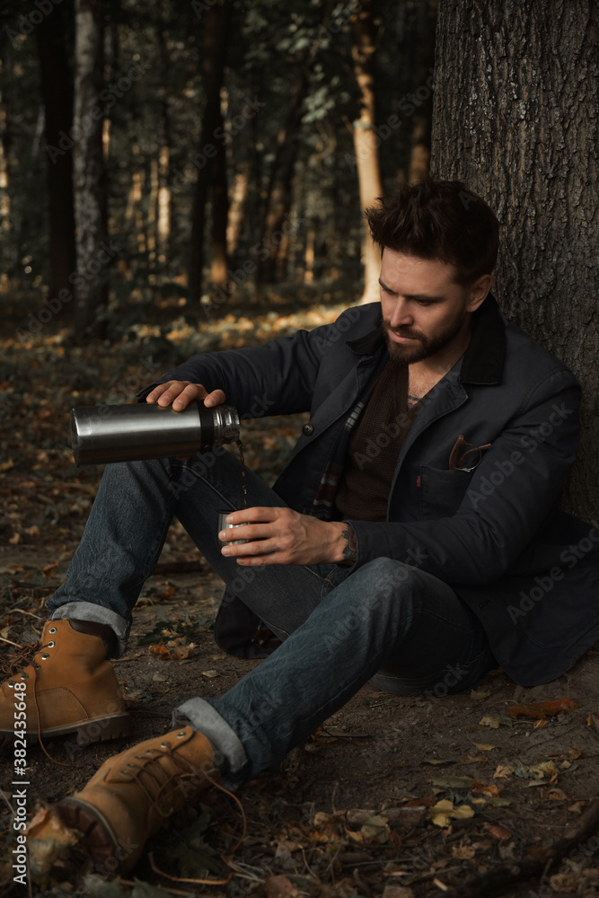 Man with thermos in the forest