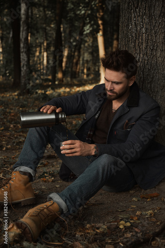 Man with thermos in the forest