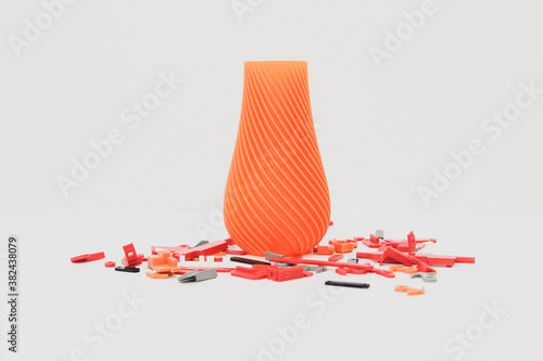Bright orange vase made from 3d printing and colorful parts. isolated on white white and blue colors, produced from polylactic acid, horizontal view photo