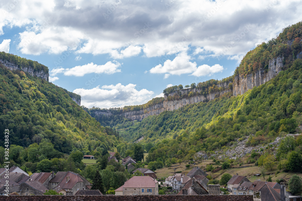 Baume-Les-Messieurs, France - 09 01 2020: View of the roof of the village of Baume-les-Moines and cliffs behind