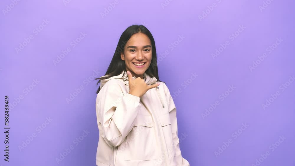 Young mixed race indian woman showing a mobile phone call gesture with fingers Young mixed race indian woman showing a mobile phone call gesture with fingers