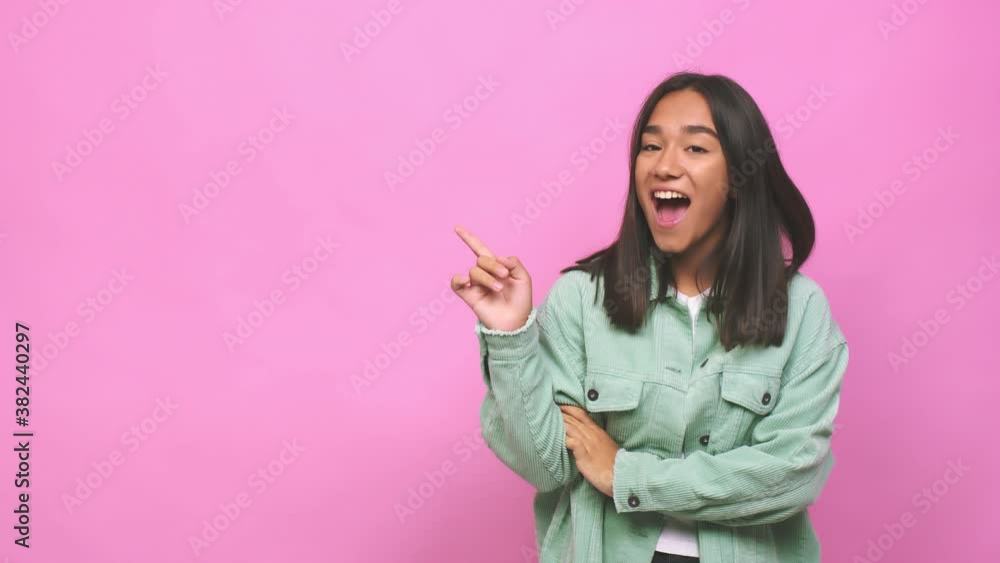 Young mixed race indian woman smiling cheerfully pointing with forefinger away Young mixed race indian woman smiling cheerfully pointing with forefinger away