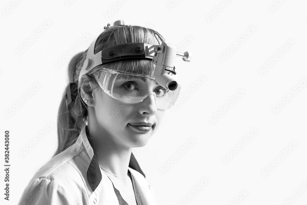 Confident ENT doctor wearing surgical headlight head light and protective glasses. Closeup portrait of female otolaryngologist or head and neck surgeon isolated on white. Confident ENT doctor wearing surgical headlight head light and protective glasses. Closeup portrait of female otolaryngologist or head and neck surgeon isolated on white.