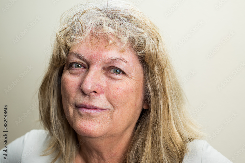 Portrait of real middle age caucasian woman with beautiful green eyes and white hair looking to the camera. Portrait of real middle age caucasian woman with beautiful green eyes and white hair looking to the camera.
