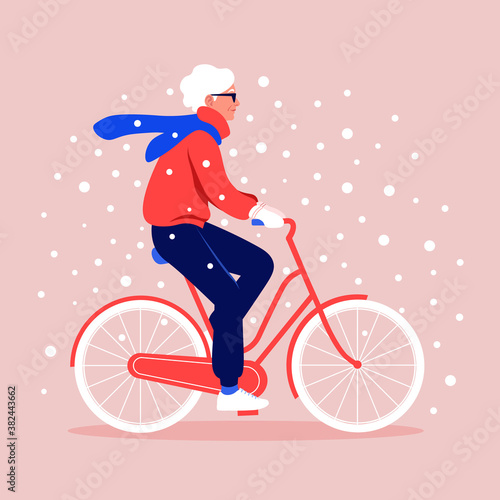 An old woman rides a bicycle under snowfall. Winter sport. Grandmother. Vector flat illustration