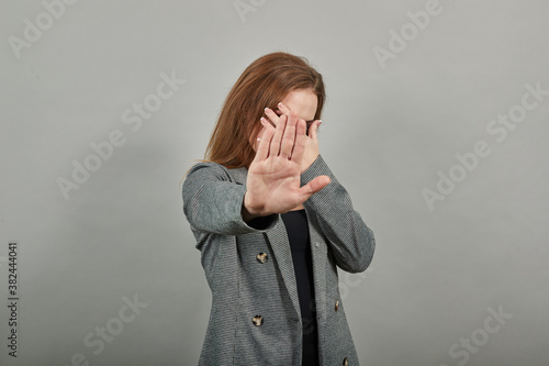 Palm arm raised air angry look straight you will not pass through facial expression harsh. Serious looking strict demands stop, pulls hand forward camera, says no, disagrees, frowns face, warning