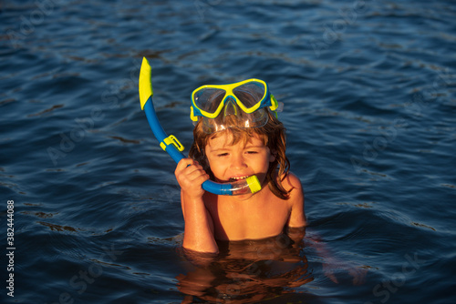 Cute kid swimming and snorkeling in tropical ocean or sea.