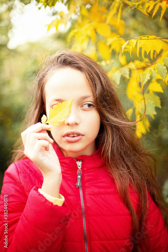 girl in the autumn forest by the tree