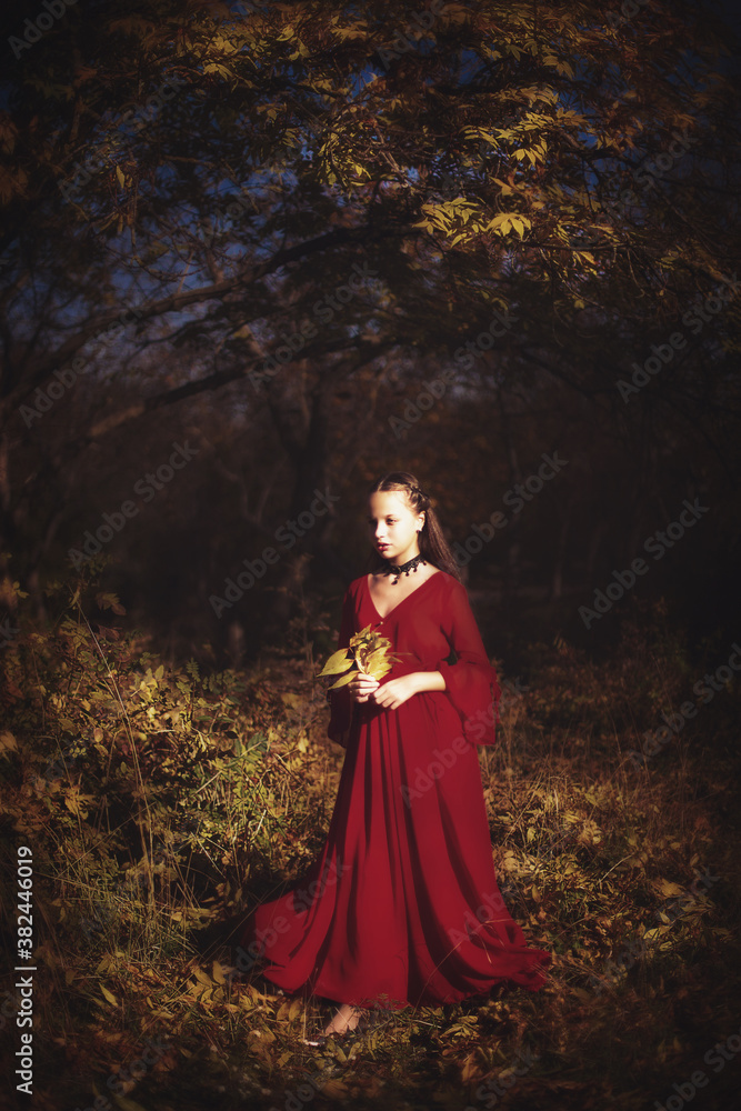 Girl in the autumn forest in a vintage red dress