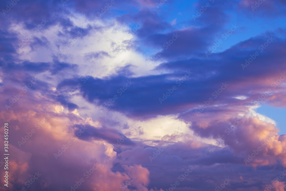 Obraz premium There are dramatic clouds in the dark sky as the sun sets. The sky is dominated by fuchsia, pink.