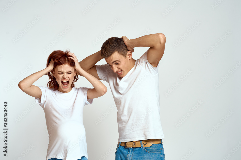 a pregnant woman and a young man are waiting for a baby on a light background emotions family love a pregnant woman and a young man are waiting for a baby on a light background emotions family love