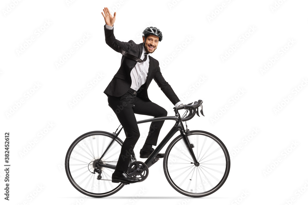 © Ljupco Smokovski - Profile shot of a businessman riding a bicycle to work and waving at camera