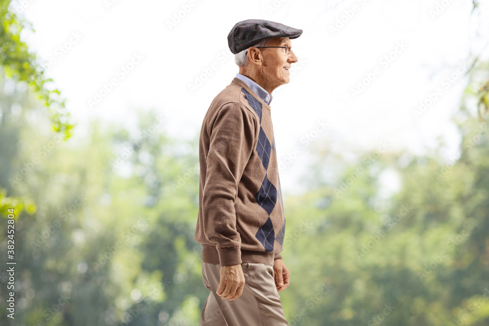 Elderly gentleman walking in a park Elderly gentleman walking in a park