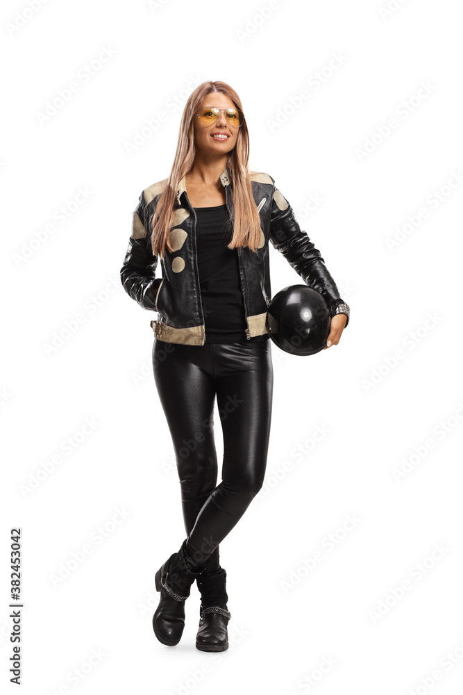 Full length portrait of a young female in leather pants holding a helmet Full length portrait of a young female in leather pants holding a helmet