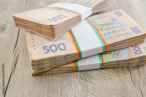 three packs of hryvnia on a wooden table. Ukrainian money. 500 hryvnia banknotes. A lot of Ukrainian money.