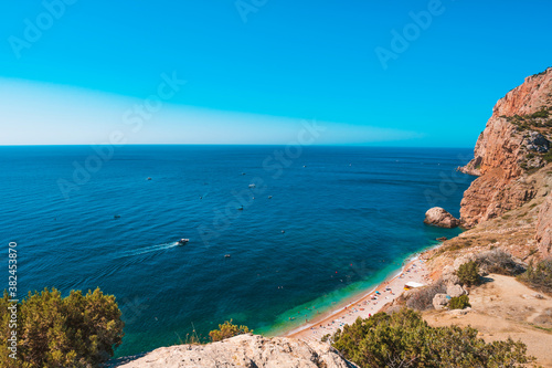 Panoramic view of the picturesque beach with white sand and azure water  top view of the beach vacationers  Crimea