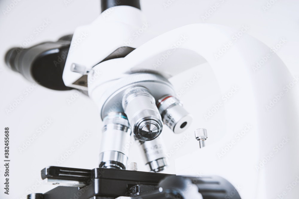 Using a biological microscope. Close-up of the microscope lens. Scientific research concept, using a microscope. Medical examinations, searching for bacteria, diseases, blood tests. Using a biological microscope. Close-up of the microscope lens. Scientific research concept, using a microscope. Medical examinations, searching for bacteria, diseases, blood tests.
