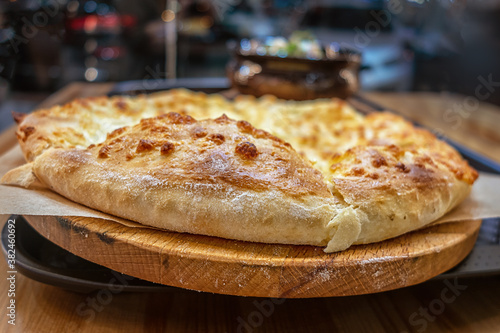 Wallpaper Mural freshly baked ruddy tortilla with cheese on a cutting board on a table in a restaurant, khachapuri - georgian meal Torontodigital.ca