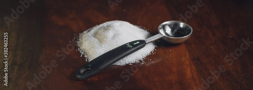 Canvas-taulu a pile of sugar on a table beside a 1 teaspoon measuring spoon
