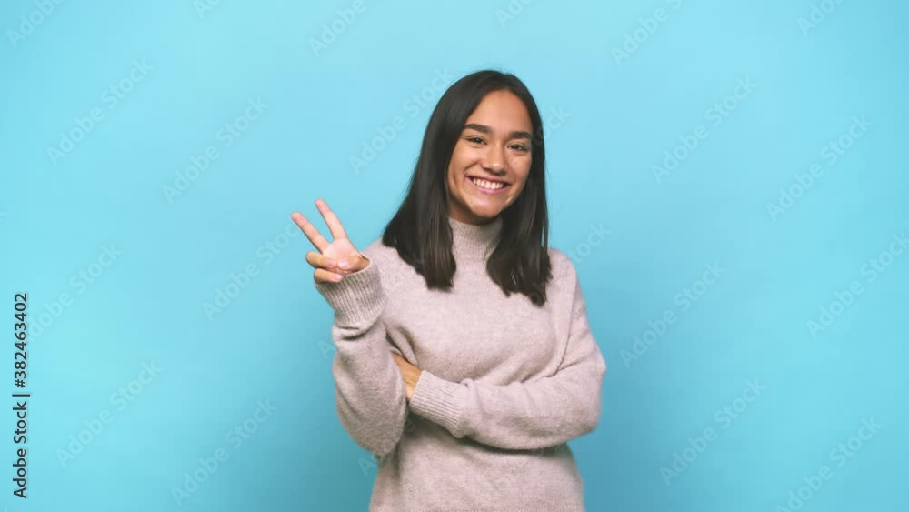 Young mixed race indian woman showing number two with fingers Young mixed race indian woman showing number two with fingers