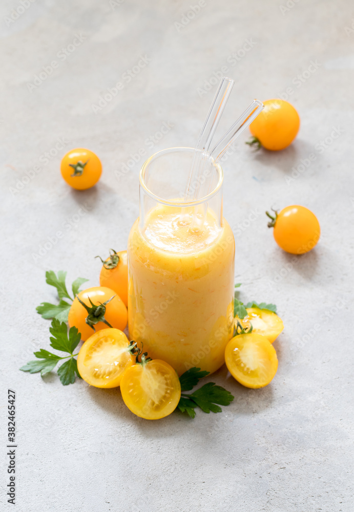 Drink cocktail yellow tomato in a glass bottle with a straw on a light background Drink cocktail yellow tomato in a glass bottle with a straw on a light background