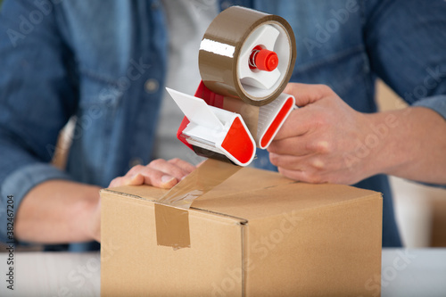 close up of person using parcel tape dispenser photo