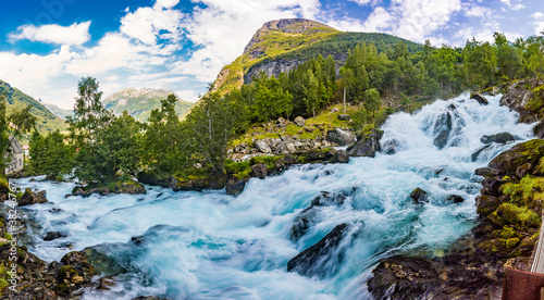 Fototapeta Naklejka Na Ścianę i Meble -  View of the river Geirangerelvi and the waterfall Storfossen in Geiranger, Norway.