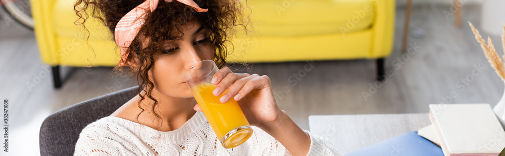 horizontal image of curly woman drinking fresh orange juice horizontal image of curly woman drinking fresh orange juice