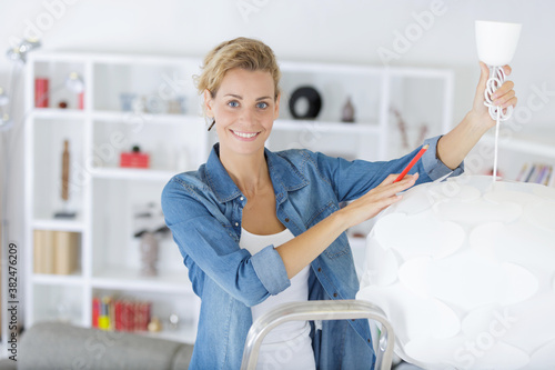 a happy woman changing a lamp