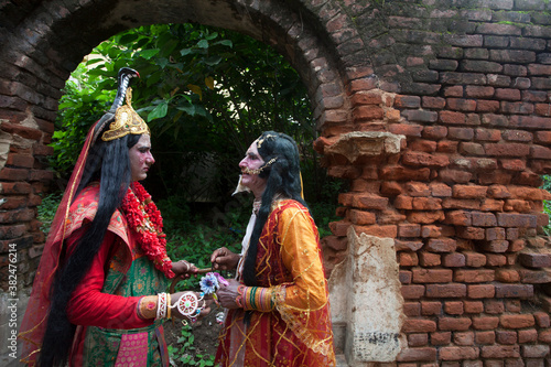 Father and son decorating themselves as Hindu God and Goddess and Holding Hands. photo