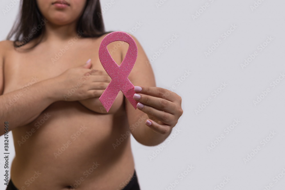 Portrait of shirtless woman holding scarlet pink ribbon use in October breast cancer awareness month BCAM Portrait of shirtless woman holding scarlet pink ribbon use in October breast cancer awareness month BCAM