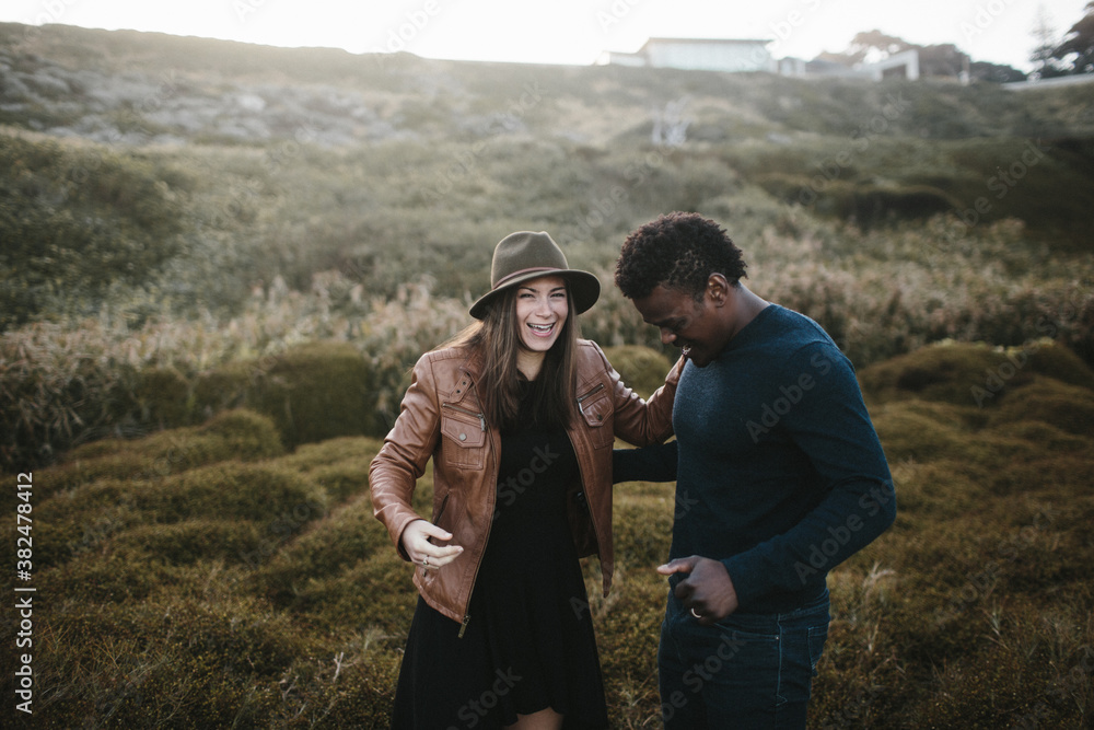 attractive couple laughing in field of dark green grass attractive couple laughing in field of dark green grass