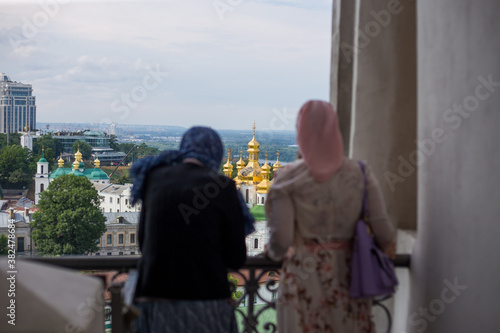 Orthodox woman in a scarf against the background of the Kiev Pechersk Lavra
