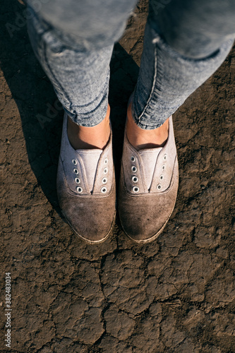 Close-up of dirty white shoes on ground