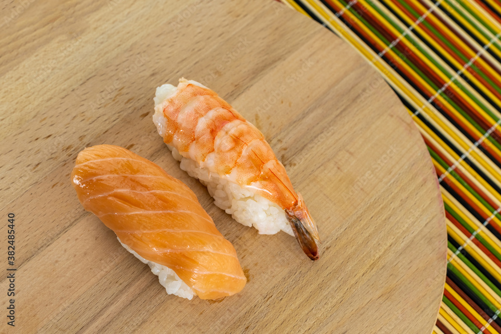 pair of sushi fresh shrimp and salmon stand on a wooden background pair of sushi fresh shrimp and salmon stand on a wooden background